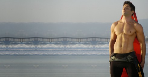 Muscular Young Man in Wetsuit on the Beach