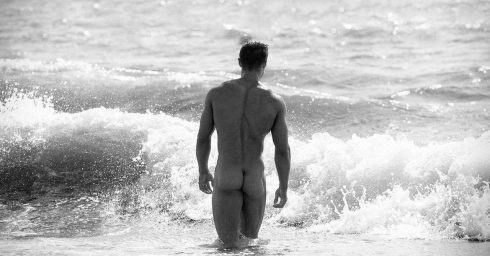 Rearview Muscular Hunk at the Edge of the Ocean