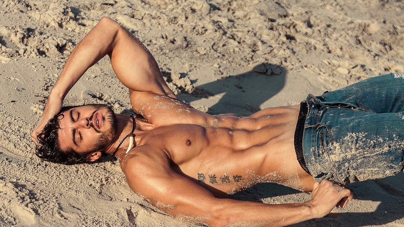 Ripped Guy Shirtless in Jeans in the Sand