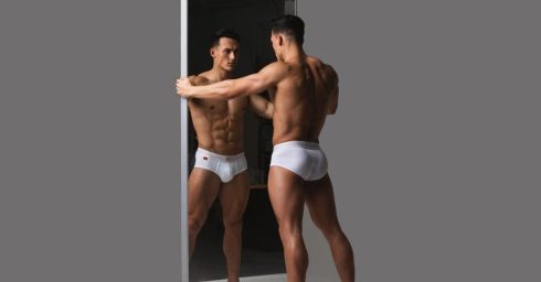 Fit Guy in White Briefs Standing at a Mirror