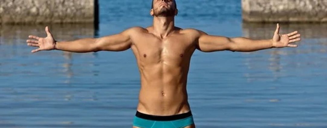 Fit Guy in a Blue Bikini by the Ocean