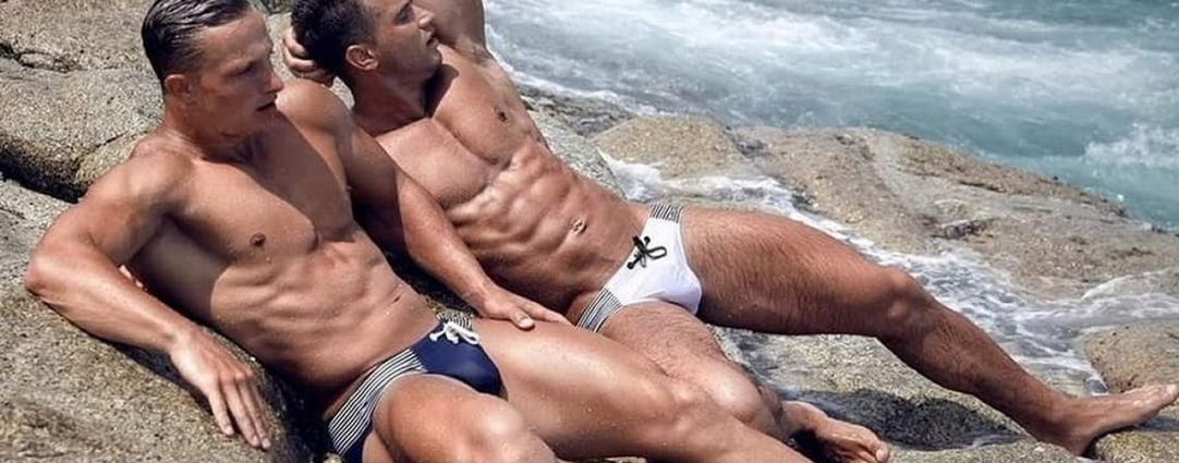 Two Hunk in Bikinis on Rocks at the Edge of the Ocean