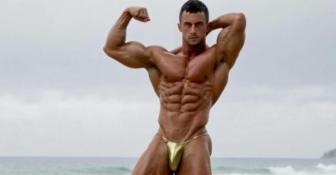 Bodybuilder in a Gold Posing Strap at the Edge of the Ocean