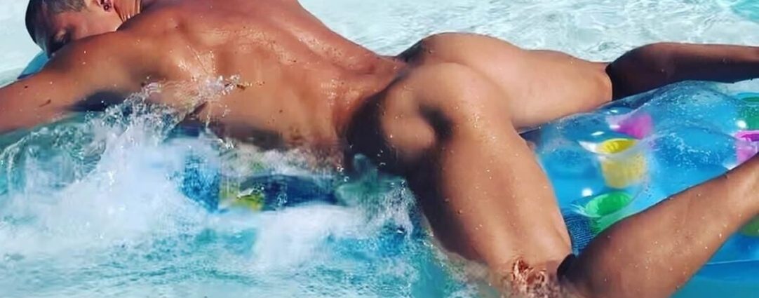 Rearview Naked Hunk Floating in a Pool