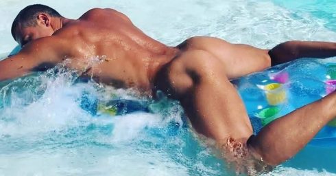 Rearview Naked Hunk Floating in a Pool