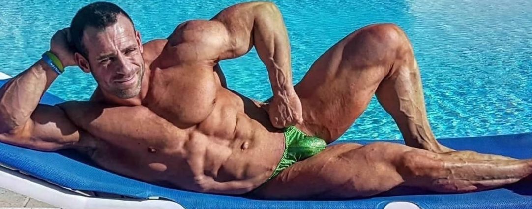 Muscular Guy in a Green Bikini Lounging by a Pool