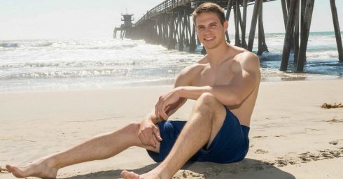 Athletic Guy in Blue Shorts at the Beach